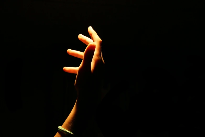 person with hand outstretched reaching up to sky