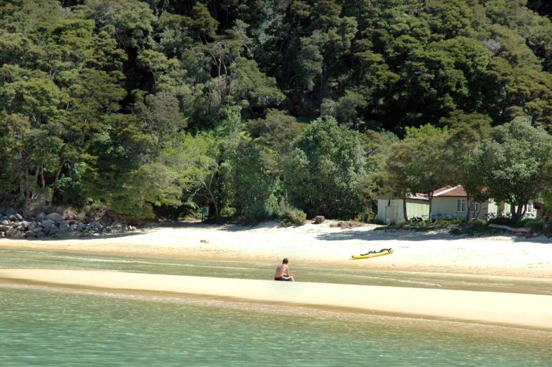 a couple sits on the edge of a body of water on their surfboard