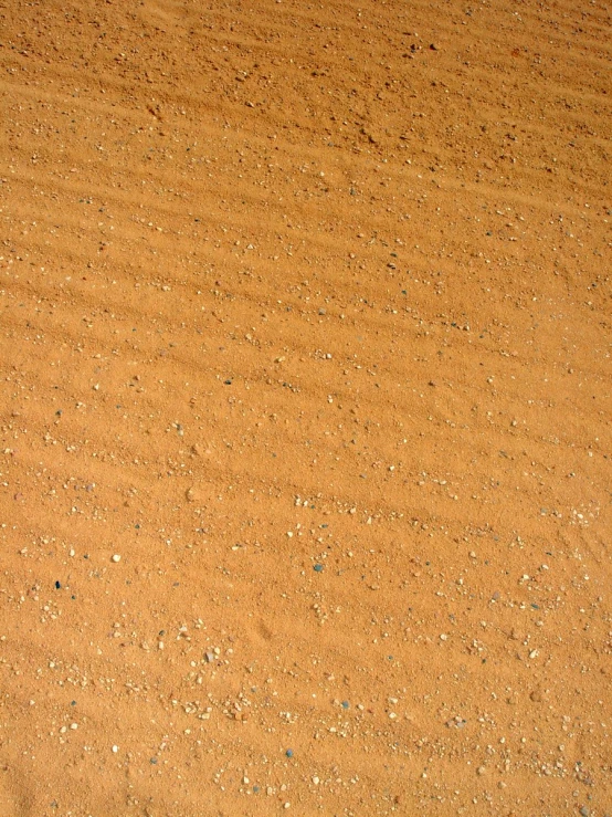 a person is walking in the sand on a surfboard