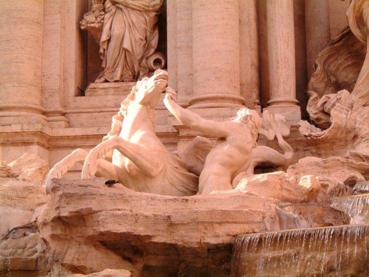 a fountain that has statues and horses next to it