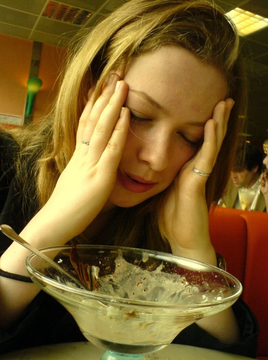 a lady sitting with her head down and holding a plate