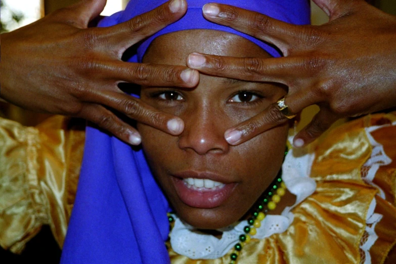 an african american woman with purple veil holding her hands together