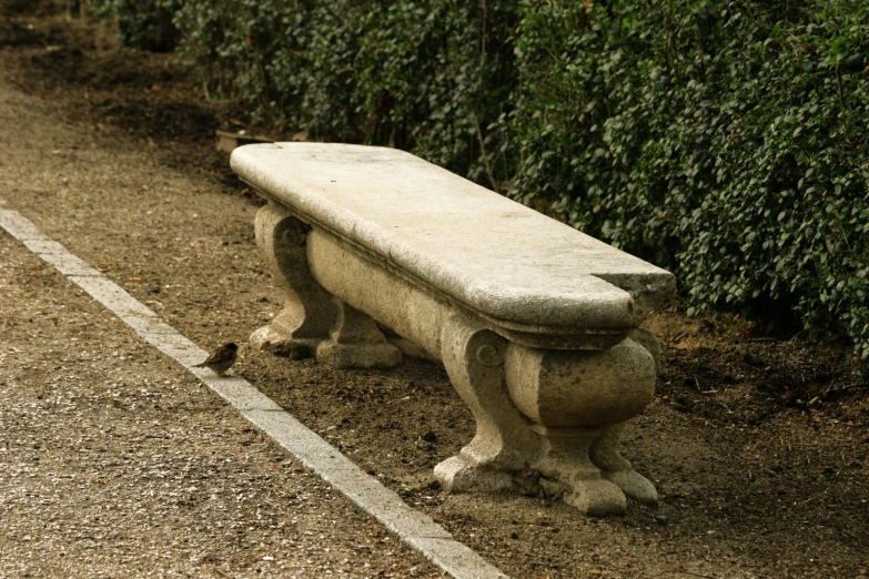 an old cement bench sitting on the side of a road