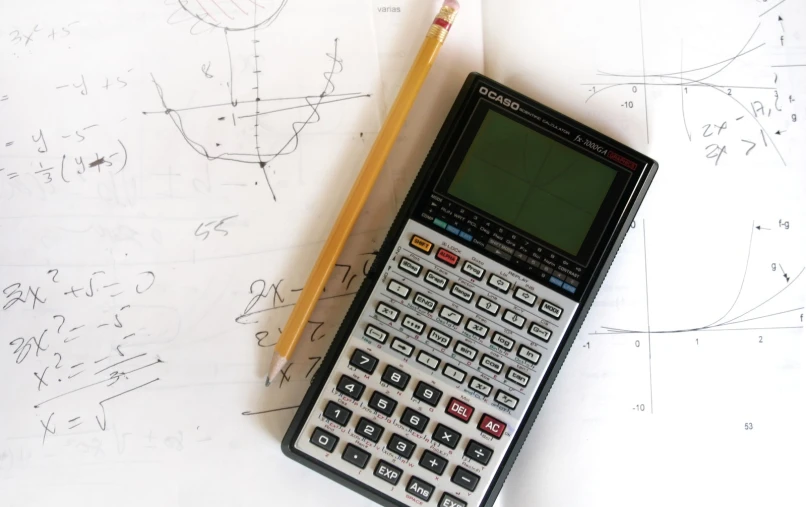 a calculator and a pencil on a construction paper