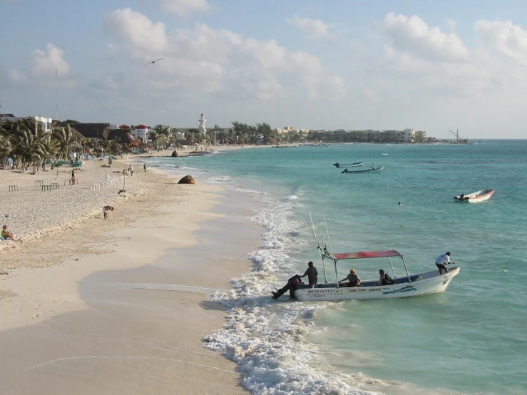 a boat sitting on top of the ocean next to a sandy beach