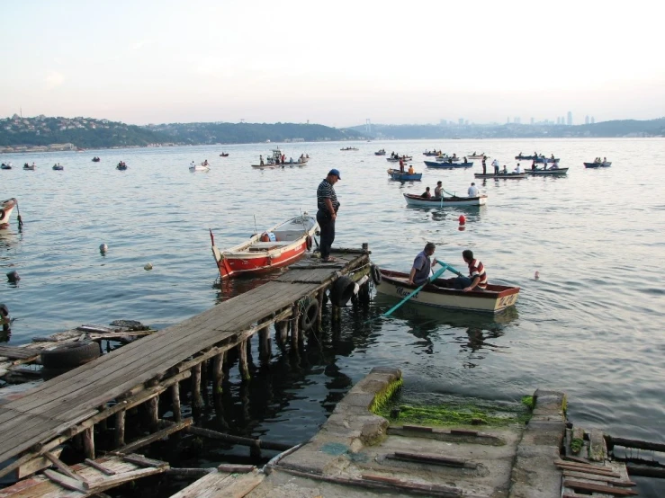 a group of people sitting around a wooden pier