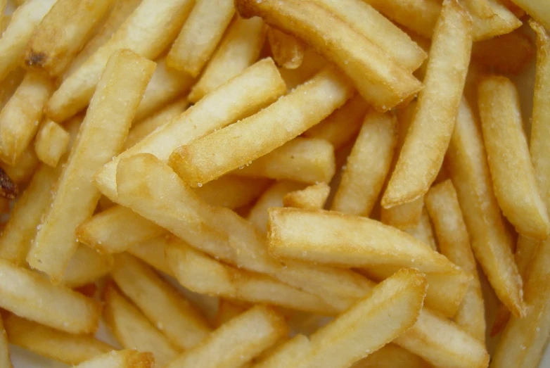 a plate with a pile of fries next to a piece of meat