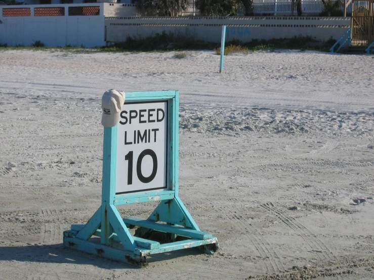 a sign showing speed limit sits in the sand