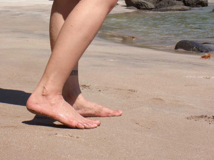 barefoot young woman's bare feet on the beach