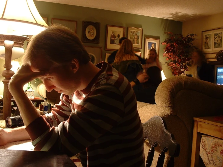 there is a man sitting at a table with a drink