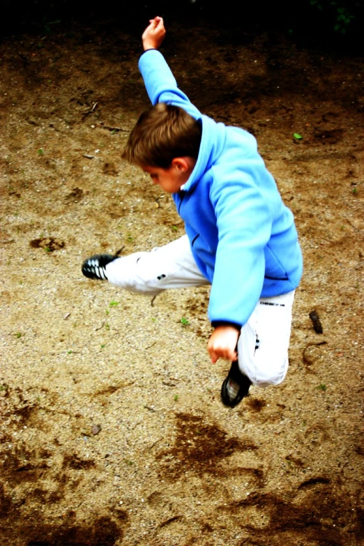  in blue sweatshirt catching a baseball with his foot