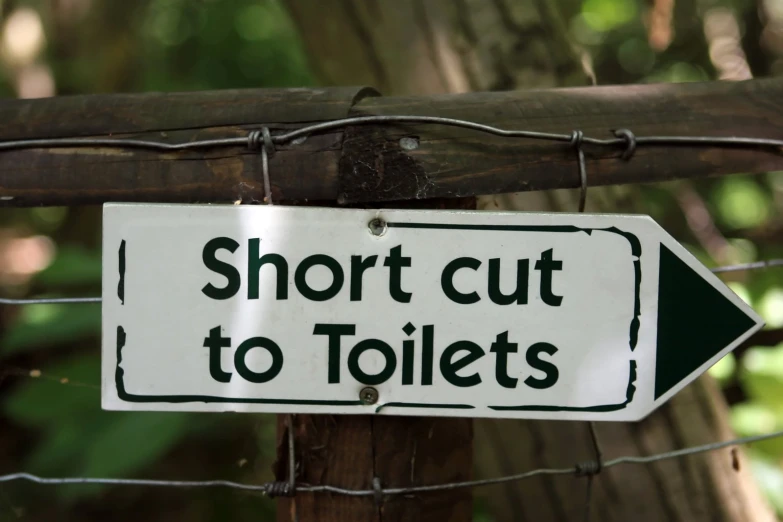 a white sign with the words short cut to toilets