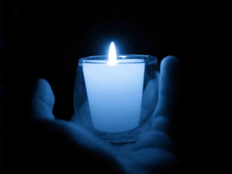 someone holding a blue candle in their hands