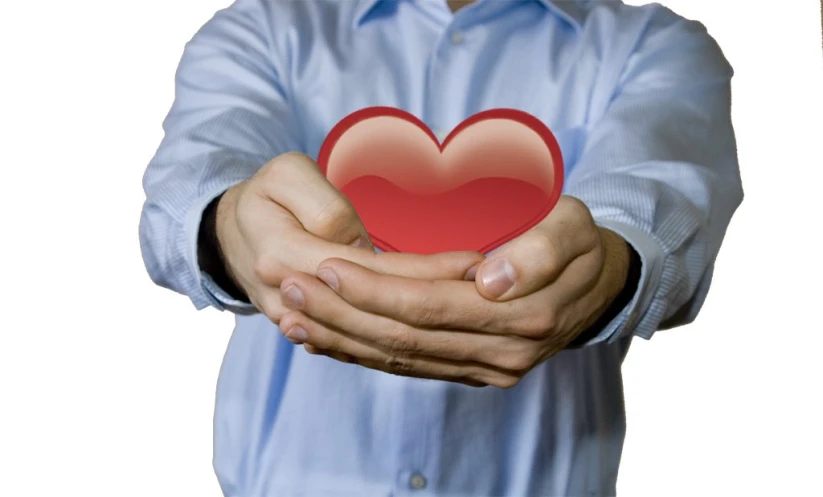 man holding a red heart against a white background