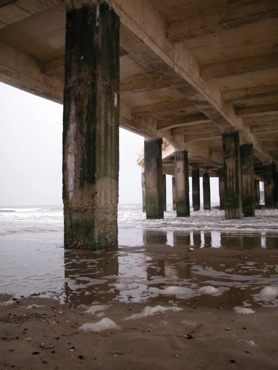 a bridge and beach with the ocean behind it