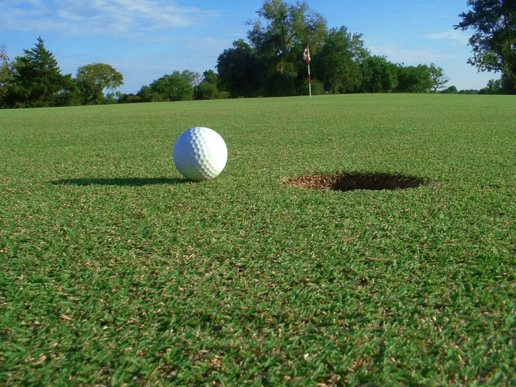 a golf ball in the middle of a hole in a green field