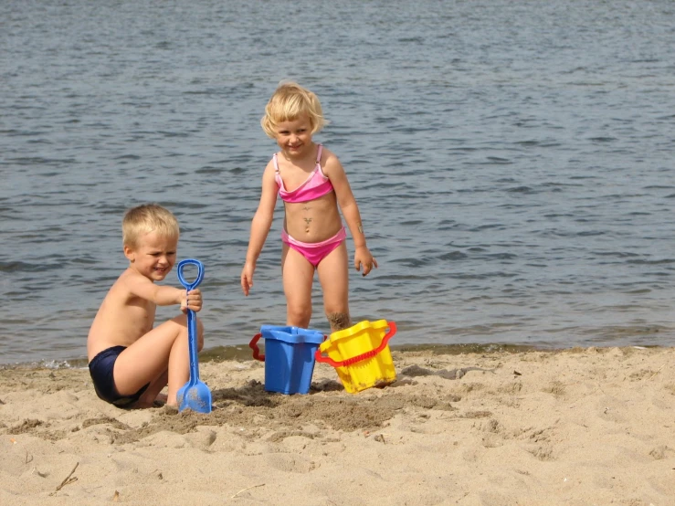 two children playing with toys at the beach