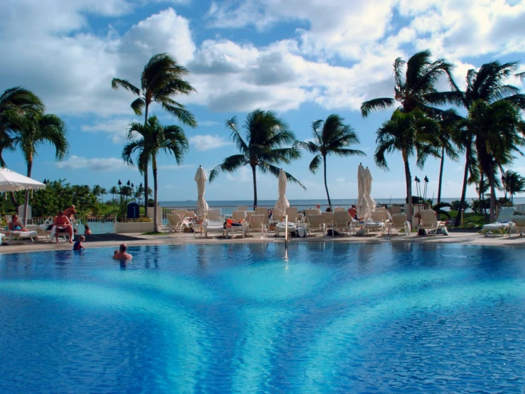 people are swimming and having fun at a resort