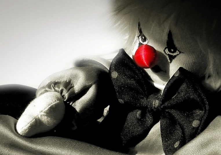 a creepy clown stuffed animal with a red nose