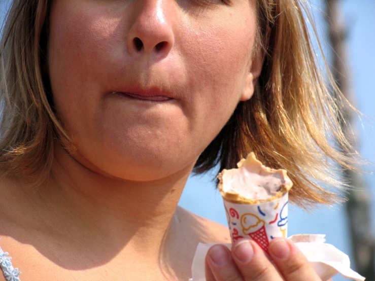 a woman eating a frosted piece of cake