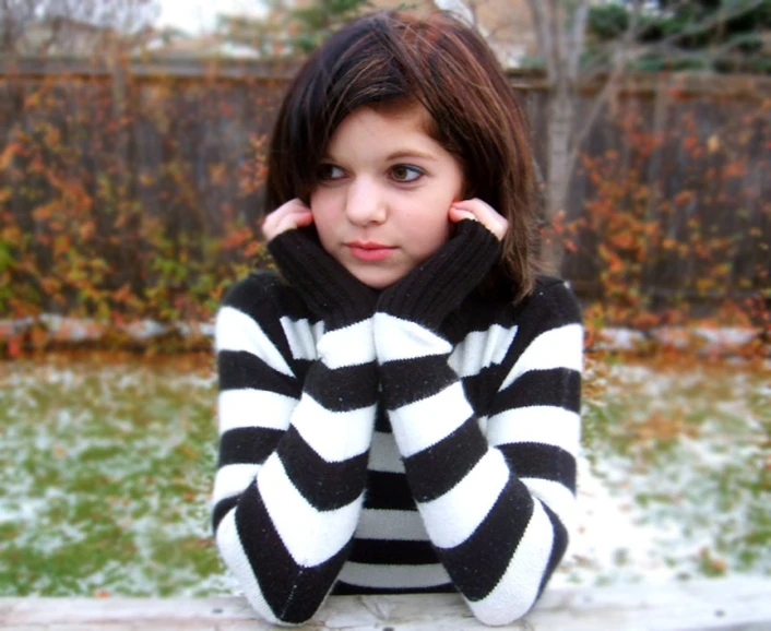 a  wearing striped sweater posing in the snow