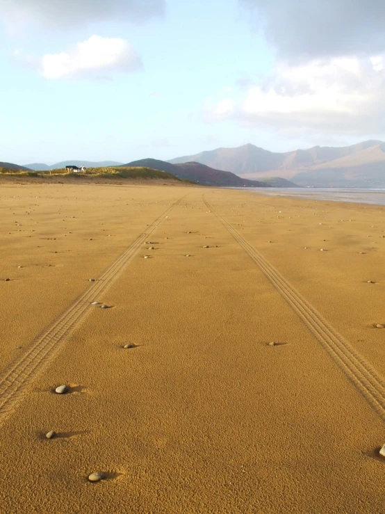 the beach has several footprints and lines in the sand