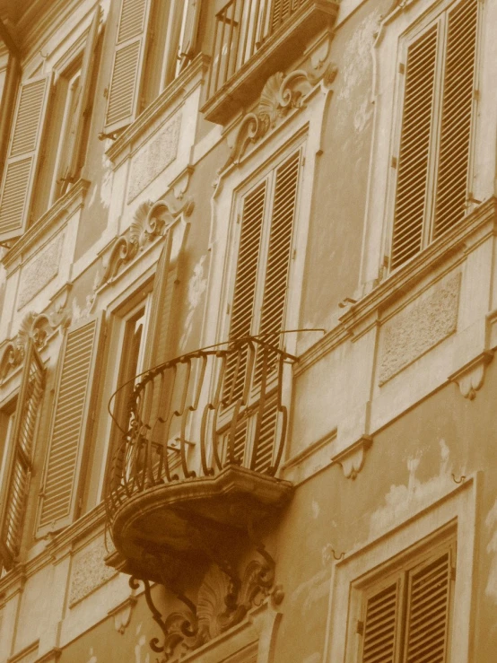 balcony and windows are seen with an old looking brick wall