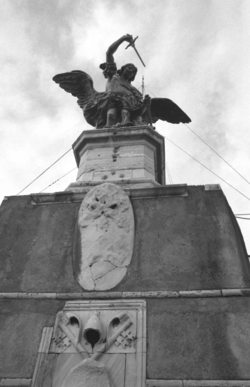 a black and white image of a building with a statue on top