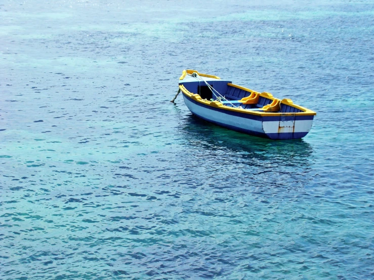 the blue and yellow boat is out in the water