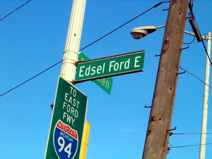 green street signs on pole with telephone poles