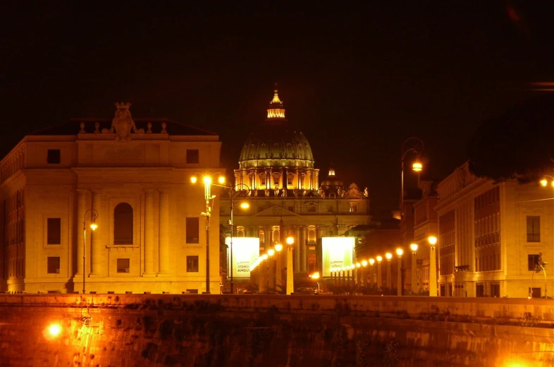 the city at night, with the building lit up and buildings on both sides