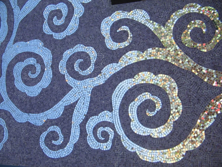 an outdoor mosaic is decorated on a blue background