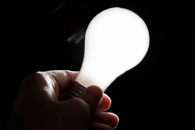 a person is holding a dim light bulb