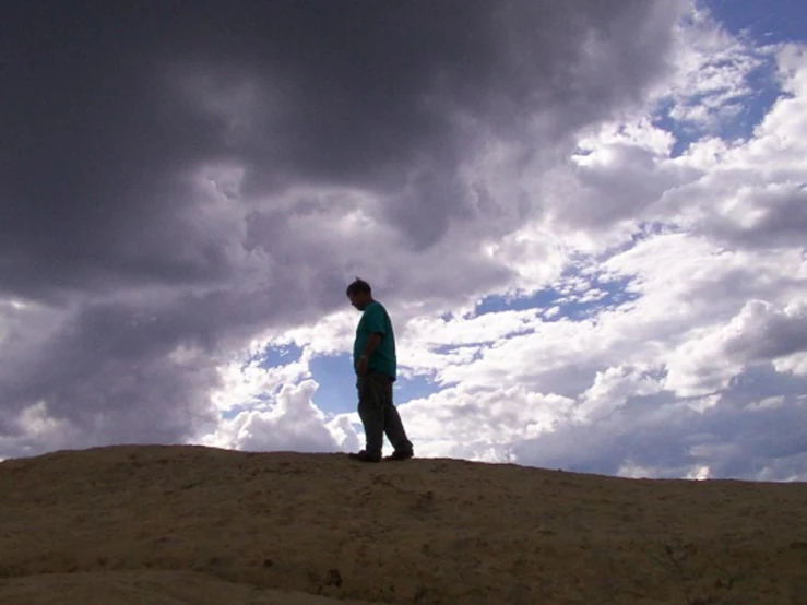 a man standing on top of a sand hill