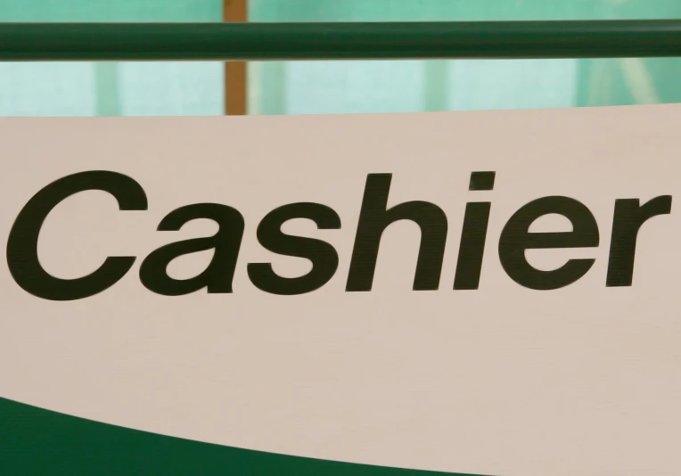 a sign advertising cashier on the side of a fence