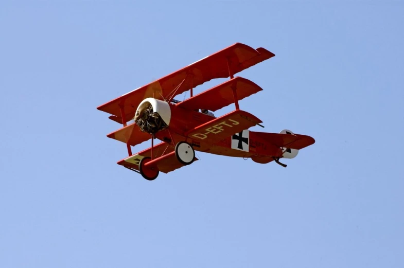 an image of an old fashioned plane flying high in the sky