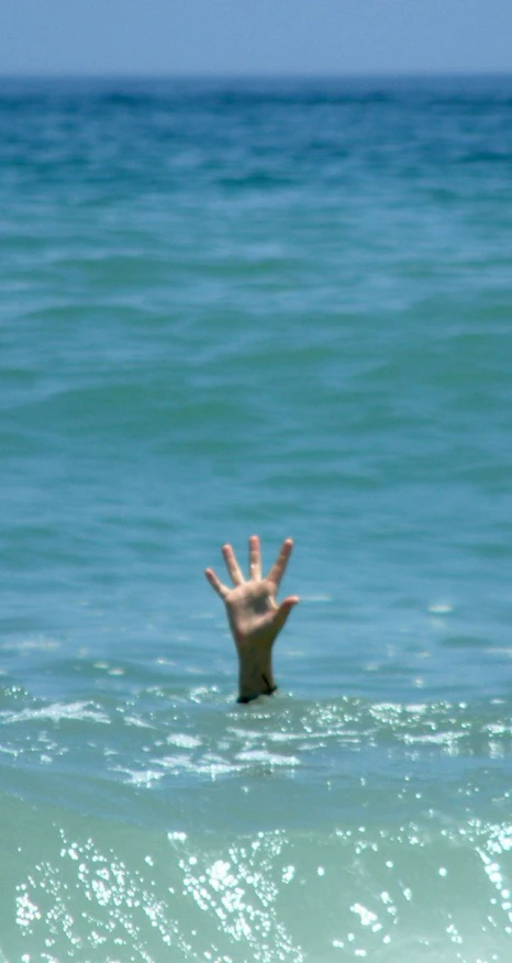 an image of a person in the ocean giving the vulcan sign