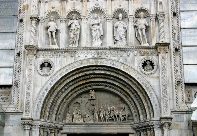 an old stone building with statues and angels above it