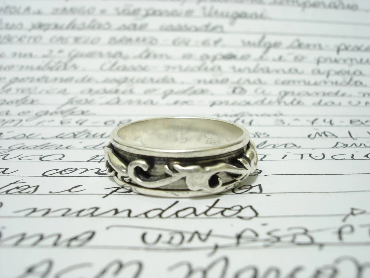 an intricate ring sits on a piece of writing