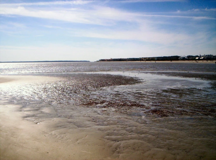 there are people standing on the sand at the beach