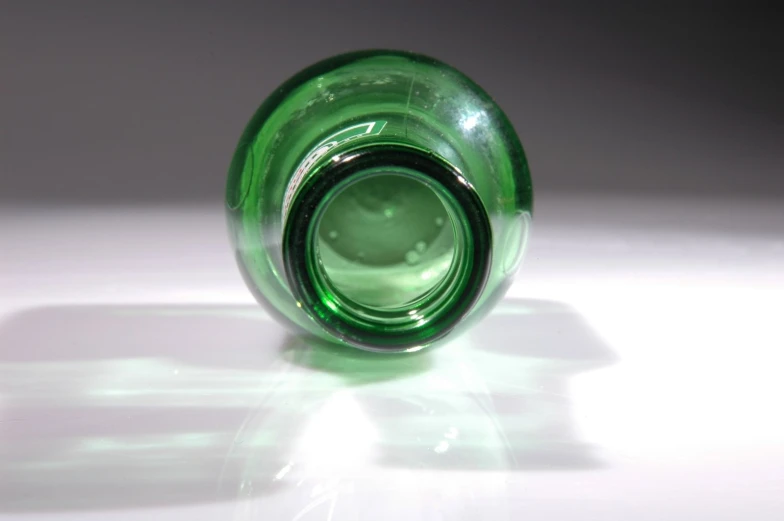 a glass green vase is sitting in the sun
