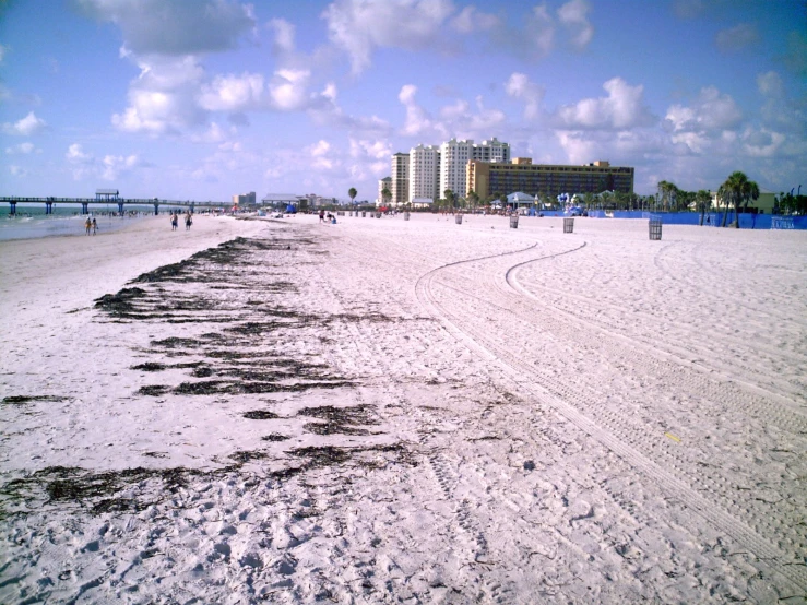 a beach with some sand and houses in the distance