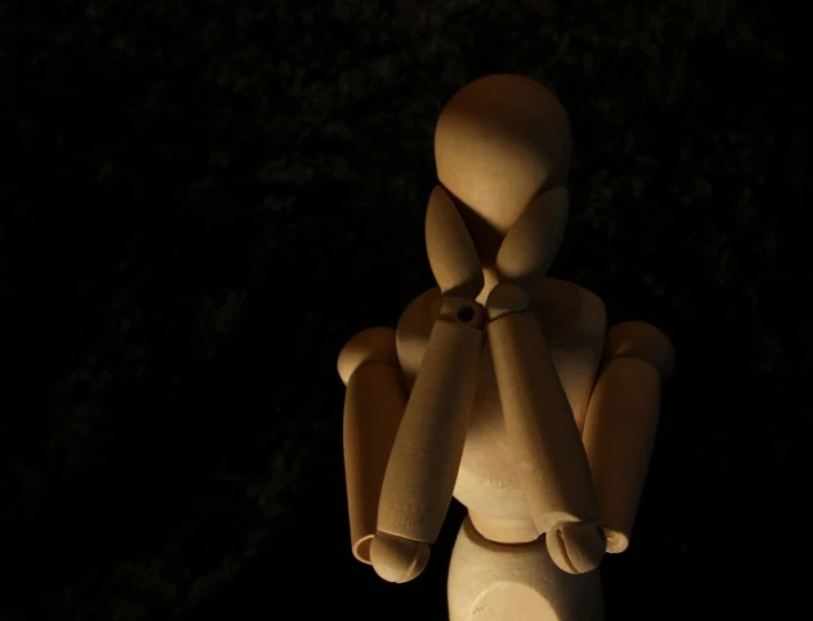 a wooden statue sitting alone on top of a table