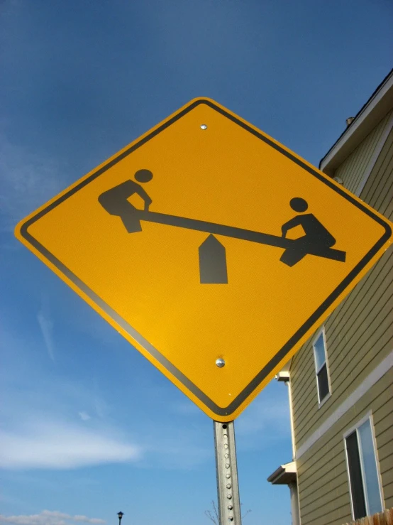 a yellow sign with a man and woman standing over a falling pedestrian sign