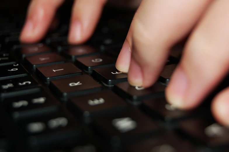 a closeup of hands that are typing on a computer keyboard
