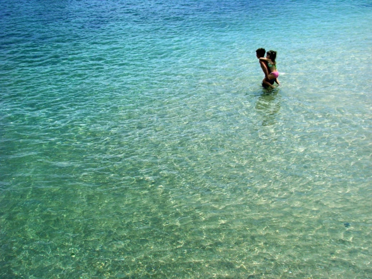 a man and a woman play in the shallow water