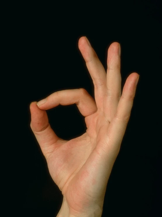 hand showing the v symbol while holding onto a black background