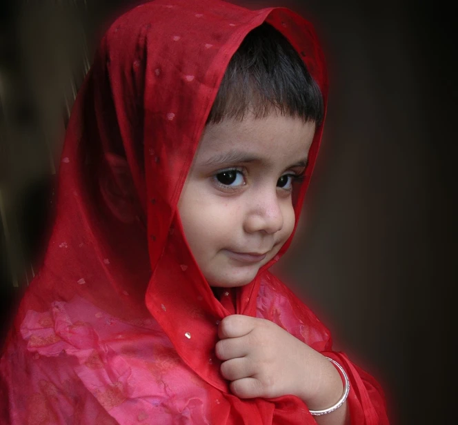 a little girl dressed in red posing for a picture