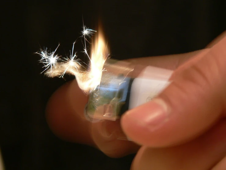 someone holding a lighter and the tip with sparks