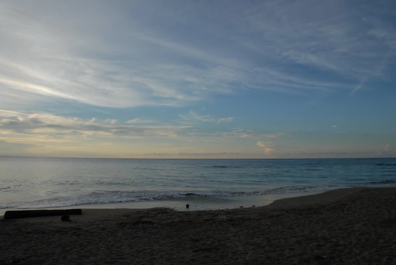 a beach in front of the ocean is empty and blue